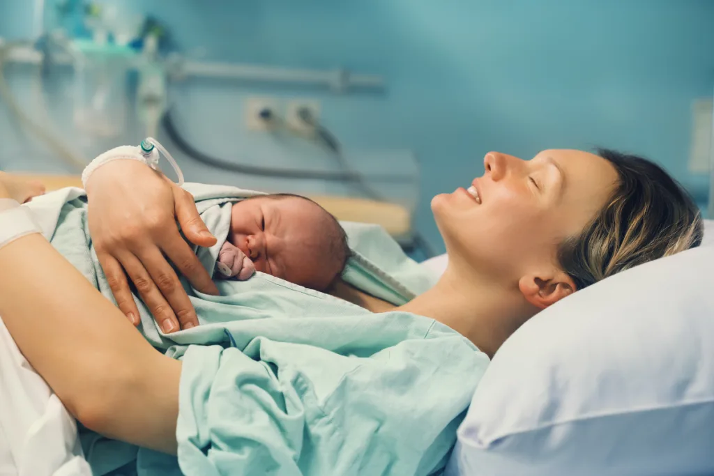Mom with baby after giving birth to baby. Skin to skin contact during the golden hour after birth. 